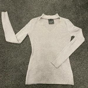 Grå, v-ringad tröja  - Grå, V-ringad tröja med en kragdetalj. Materialet är stickat ribbat. Den är i storlek S. Väldigt skönt material 