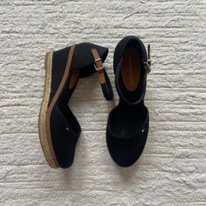 Tommy hilfiger Wedges Storlek: 38 - Säljer mina Tommy hilfiger klackar i färgen svart. De är ungefär 7cm höga och passar perfekt till student och fest😉 Användna några gånger men i bra skick!