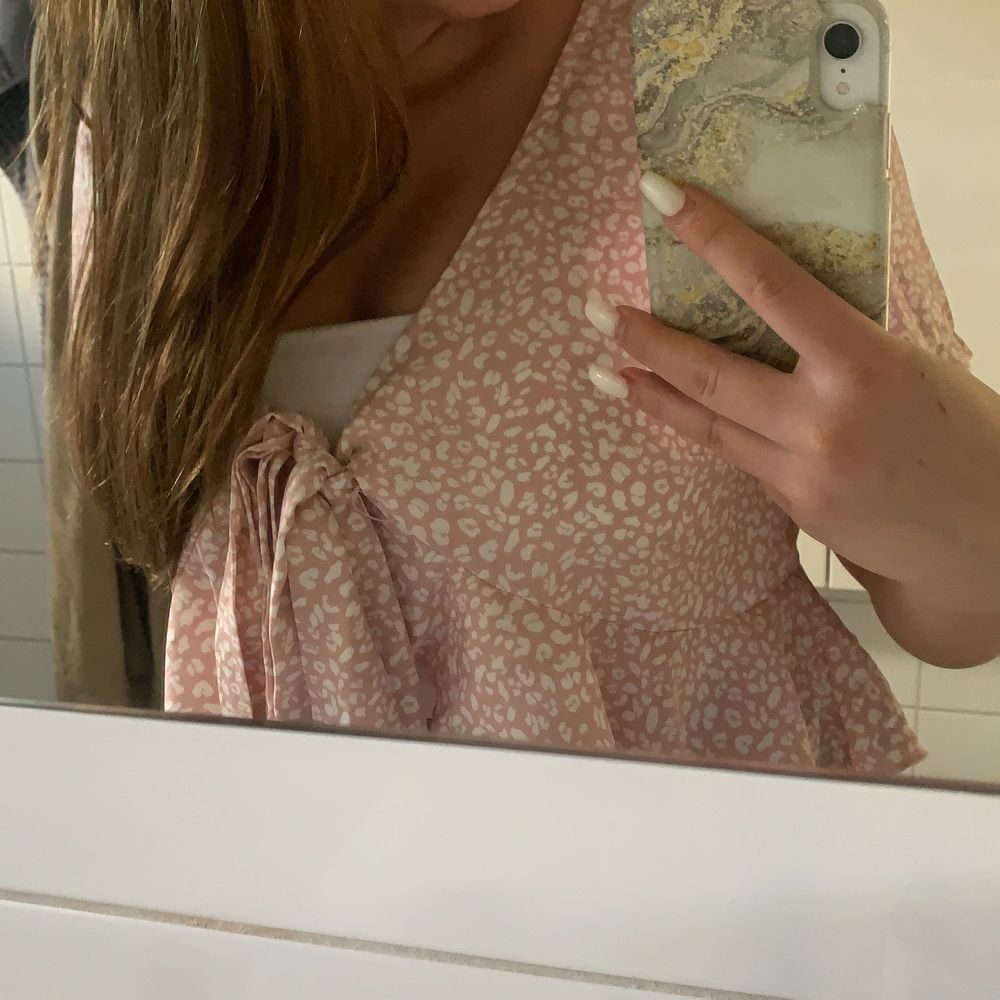 Rosa blus med vitt mönster och volanger som man knyter vid brösten 💖 säljer även bandeu toppen under i ett annat inlägg!! Den är storlek m men passar mig som har s. Blusar.