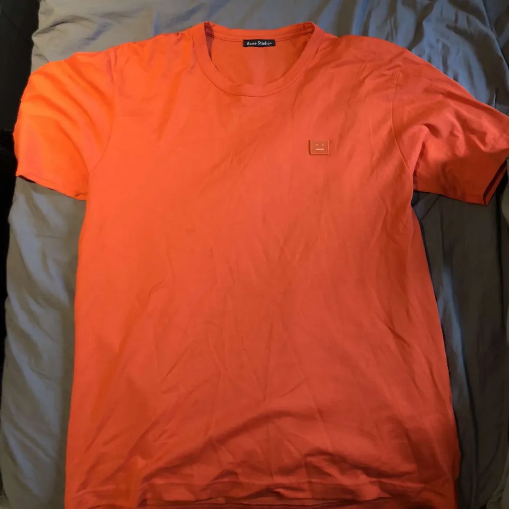 Säljer min tvär sköna acne face tisha i en skön orange färg storlek L. T-shirts.