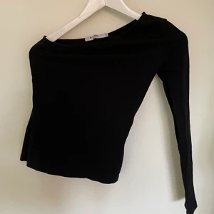 Svart top - Svart top med en arm och bar axel. Från NAKD stl XS, pris 50kr