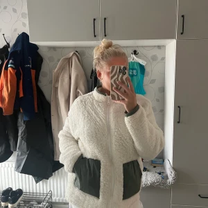Pälsjacka - Vit tunnare päls jacka med gröna fickor, stor i storleken. inköpt för 499kr