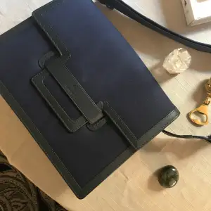 Marinblå väska med svarta läderdetaljer. Väskan är endast andvänd 2 gånger.