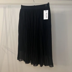 Plisserad kjol från NA-KD - Jättefin svart plisserad kjol från NA-KD i storlek M. Ny med prislapparna kvar!
