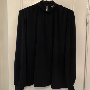 Svart blus  - Svart blus med hög krage. Väl använd. 