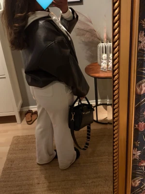Brun skinnjacka från Pull&Bear - Snygg brun skinnjacka från Pull&Bear med oversized passform, dragkedja framtill och klassisk krage. Jackan har två sidofickor och ett bälte i midjan för extra stilpoäng. Perfekt för dig som vill ha en trendig och avslappnad look. Använd fåtal gånger och säljer därav pga brist sv användning. Nypris 559kr