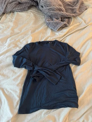 Mörkblå långärmad topp - En enkel och stilren mörkblå långärmad topp med rund hals. Perfekt att matcha med jeans.Tillverkad i mjukt material som känns skönt mot huden.