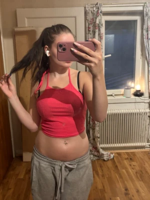 Rosa ribbad croppad linnetopp - Säljer en rosa croppad linnetopp med tunna axelband och ribbad struktur. Toppen har en figurnära passform och är perfekt för varma dagar eller som ett statement-plagg. Materialet känns mjukt och stretchigt.