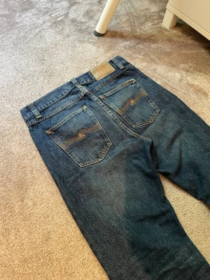 Nudie Jeans - UTFÖRSÄLJNING‼️  Säljer ett par nudie jeans med snygga slitningar  * Model/passform: Gritty Jackson * Storlek: W28/L32 * Skick: Mycket bra skick * Färg: Blå * Mått: Bredd-38/39cm + Längd-108cm