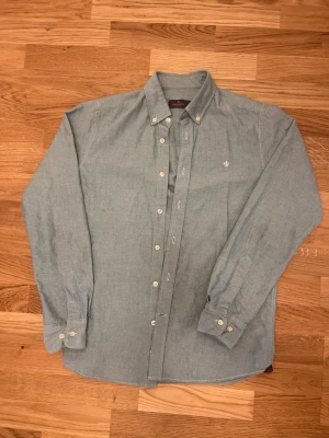 Ljusgrön skjorta från Morris - Klassisk ljusgrön skjorta från Morris med button-down krage och vita knappar. Skjortan har lång ärm och en liten broderad logga på bröstet. Tillverkad i mjuk bomull som känns skön mot huden.