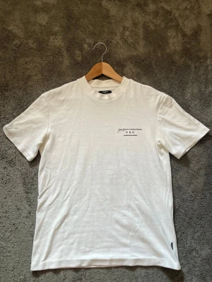 Vit premium t-shirt med tryck - Säljer en vit premium t-shirt med diskret tryck på bröstet från Jack&Jones. T-shirten har rund halsringning och korta ärmar. Nästintill oanvänd. Pris går att diskutera!