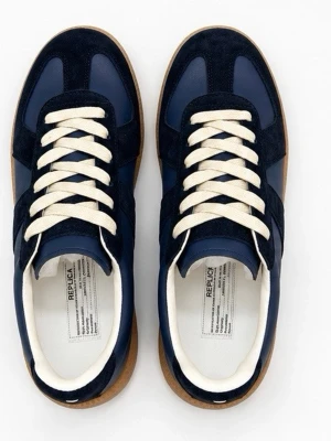 Maison margiela gats mörkblå - Snygga marinblå sneakers med kontrasterande mockadetaljer och vita snören. Skorna har en klassisk låg profil och en brun gummisula som ger retrovibbar. Ovandelen är i en mix av slätt läder och mocka för en cool och stilren look. Väljer o sälja dessa eftersom jag fick dom i fel storlek och passar inte mig