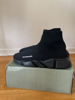 svarta sneakers - Svarta sneakers med stickad ovandel i stretchigt tyg och chunky sula. Minimalistisk design med vit logga på sidan och ribbad kant vid ankeln. Snygga och bekväma skor som ger en futuristisk vibe till din outfit.