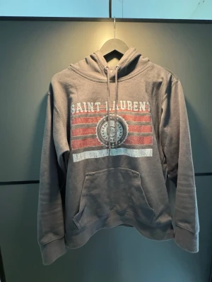  Saint Laurent Hoodie - Jag säljer denna as feta hoodie från Saint Laurent i storlek S,och anledningen till att jag säljer den är för att jag har vuxit ur den. Jag är 182 Skriv vid frågor eller funderingar🤗