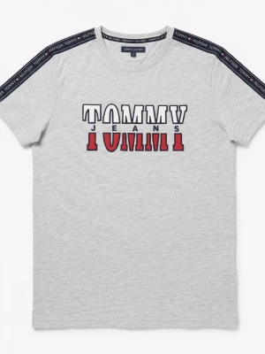 Grå Tommy Jeans t-shirt med logga - Snygg ljusgrå t-shirt från Tommy Jeans med stor logga i vitt, svart och rött på bröstet. T-shirten har korta ärmar och mörkblå band med text på axlarna. Tillverkad i mjuk bomull för skön känsla.