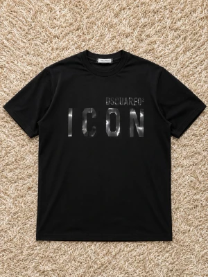 Svart ICON t-shirt från Dsquared2 - Snygg svart t-shirt från Dsquared2 med glansig 'ICON'-text framtill. Klassisk passform och rund halsringning. Perfekt för dig som vill ha en stilren och trendig look.