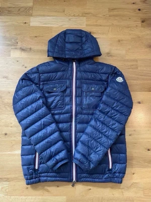 Moncler jacka - Säljer en jättefin Moncler douret i marinblå färg | Storlek L men sitter mer som M | jätte fin i skicken! | om ni har frågor så kan ni skriva till mig på pm