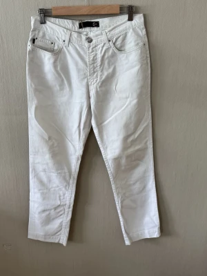 Just Cavalli Jeans / Herr / W33 L27 – Vit / Croppad passform - Snygga vita jeans med rak passform och klassisk femficksdesign. Jeansen har bälteshällor, knappgylf och är tillverkade i ett mjukt denimtyg. Perfekta för en clean och fräsch look. Midja; 40 cm     0080