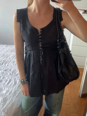 Svart linnetopp med snörning - Snygg svart linnetopp med snörning framtill och knyt i midjan. Köpt i en vintage butik i Milano 