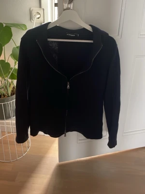 Mörkblå hoodie från J.Lindeberg - Säljer en blå hoodie från J.Lindeberg med dragkedja framtill och huva. Enkel och stilren design som passar till det mesta. Perfekt för dig som gillar klassiska plagg med en modern touch.