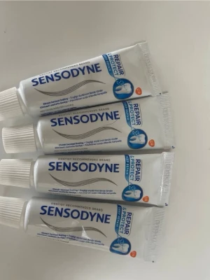 Sensodyne tandkräm små tuber - Tre små tuber Sensodyne Repair & Protect tandkräm. Tuben är vit med blå och silver detaljer och har skruvlock. Perfekt storlek för resan eller att ha i väskan. Tandkrämen är speciellt framtagen för känsliga tänder.