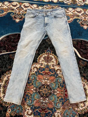 Ljusblå slim fit jeans från Zara Man - Säljer ett par ljusblå slim fit jeans från Zara Man. Jeansen har klassisk femficksdesign, bälteshällor och knappgylf. Materialet är mjukt denim med en tvättad look som ger en avslappnad vibe. Perfekta till en casual outfit.