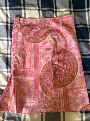 Mönstrad rosa kortkjol - Säljer en unik kortkjol i rosa med bruna och guldiga detaljer och ett coolt, orientaliskt inspirerat mönster. Kjolen har en rak passform och materialet känns mjukt och lätt.💗😊