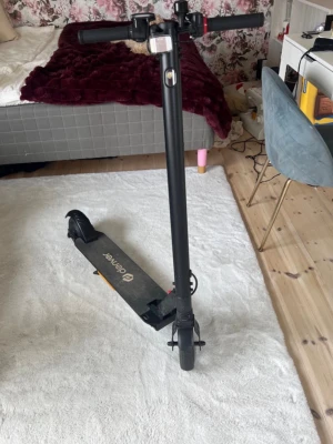 Svart elscooter från Denver - Säljer en svart elscooter från Denver med robust ram och två hjul. Scootern har handtag med grepp, framlykta och fotplatta med Denver-logga. Perfekt för att ta sig runt snabbt och smidigt i stan.