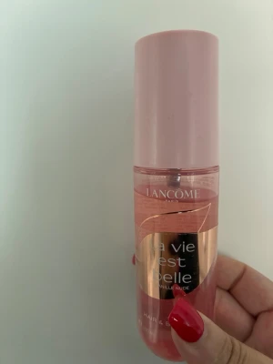 Lancôme La Vie Est Belle Parfym 100 ml - Fräsch och feminin parfym från Lancôme, La Vie Est Belle, i en rosa plastflaska med matchande lock. Flaskan rymmer 100 ml och har en elegant design med guldiga detaljer. Perfekt för dig som gillar söta och blommiga dofter.