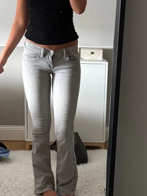 Grå Lågmidjade bootcut jeans  - Lågmidjade bootcut jeans från Gina säljer då de är för små