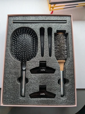 Dyson hd19 + tillbehör - Snyggt set från Dyson med svart paddelborste, rundborste i metall, två stylingklämmor och två hårclips. Perfekt för att fixa olika frisyrer och styla håret som ett proffs. Allt ligger i en stilren förpackning och verktygen har en modern design. Oanvänd.