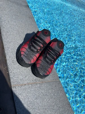 Röd/svarta Nike airmax tn’s - Fina Nike tn skor som har vart varsamt använda då jag växte ur dem snabbt. Nyligen rengjorda superbra skick inte alls slitna på nåt sätt, köpta för mindre än ett år sedan på stockX för 1600kr använda fåtal gånger. Storleken är 38,5 men funkar fint för storlek 40-41 fötter oxå. 