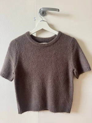Brun stickad kortärmad tröja - ⚠️Helt oanvänd med lappen kvar⚠️köpt på New Yorker för 179kr. Mysig brun stickad tröja med korta ärmar, perfekt nu till hösten. 