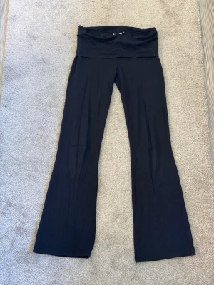 Svarta yogapants bootcut med låg midja - Säljer ett par svarta  yogapants med bootcut-ben och låg midja. Mjukt och stretchigt material som sitter skönt på kroppen. 