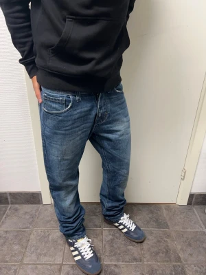Vintage Jack & Jones jeans - Snygga vintage jeans från Jack & Jones. Storlek 30 men sitter mer som 29 i midjan. Mycket bra skick. A=39CM B=102CM C=18CM. Modellen är 173cm, 64kg. Pris kan diskuteras!!