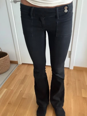 Svarta bootcut jeans från Gina 14+ - Säljer mina fina Svarta bootcut jeans från Gina 14+ för att den är för små. Är lite små i storleken brukar ha 36 i jeans. Köptes i oktober och har använts men har tagits väl hand om. Saknas en knapp se bild 3 men påverkar inte knäppningen för det finns två andra knappar som stänger jeansen.  Inga slitningar på nedre kanten. Skickas nytvättade💗