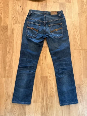 Nudie jeans Thin finn - Säljer ett par Nudie jeans med fina slitningar fram och bak på jeansen. Höft: 38 cm, lårbredd: 22cm, längd: 96 cm. Skriv vid fundering av storlek!