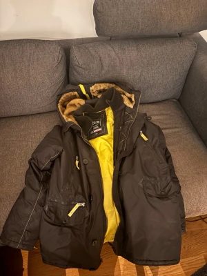 Alpha industries jacka - Snygg Alpha industries jacka med gul dragkedja och detaljer samt gul insida. Jackan har flera fickor, huva med fuskpäls och med Alpha industries patchen på ärmen. Perfekt för kalla dagar och riktigt varm.  Priset går att diskutera 
