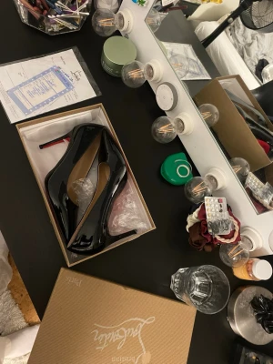 Svarta lackpumps med röd sula - Säljer ett par ikoniska svarta lackpumps från Christian Louboutin med klassisk röd sula och spetsig tå. Skorna har hög klack och elegant siluett, perfekta för att lyfta vilken outfit som helst. Kommer i originalkartong.
