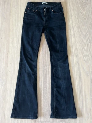 Svarta bootcut jeans - Säljer ett par svarta bootcut jeans med utsvängda ben och och ganska hög midja. De är lite missfärgning på de men annars bra skick.
