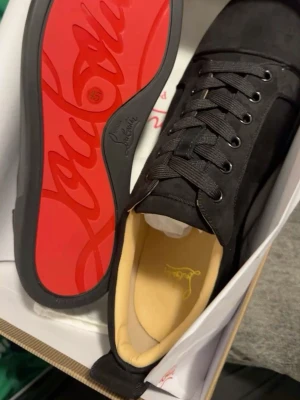 Svarta sneakers med röd sula - Säljer några svart röda skor som inte passade min son 