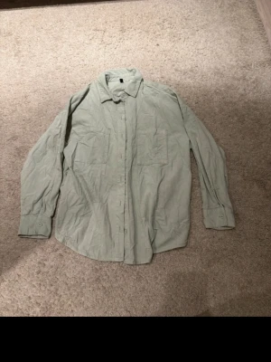 Ljusgrön manchester-skjorta H&M Divided - Säljer en ljusgrön skjorta i mjuk manchester från H&M Divided. Skjortan har två bröstfickor, klassisk krage och knäppning framtill. Perfekt oversized look och långärmad modell som passar till många olika stilar.