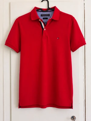 Tommy Hilfiger röd piké – Slim Fit - Röd piké från Tommy Hilfiger i Slim Fit. Klassisk modell med liten broderad Tommy Hilfiger-logga på bröstet och marinblå/vita/röda detaljer vid knappslån. Väldigt lätt att matcha till jeans, chinos eller shorts. Skick: Mycket bra, inga fläckar eller skador! Storlek: S Kan skicka mått eller fler bilder vid intresse 📦