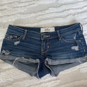 Mörkblåa hollister shorts - Säljer ett par jätte snygga lågmidjade blåa jeansshorts ifrån Hollister! Bra skick, använda få gånger. Storlek W25 men skulle säga XS/S. Midjemåttet: ca 36,5cm Priset kan diskuteras och jag kan ofta posta samma dag!!☺️