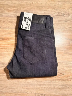 Tiger of Sweden W29 L34 - Snygga tiger of Sweden i rak modell med klassisk femficksdesign och silverfärgade nitar. Jeansen har en stilren look och är tillverkade i ett kraftigt denimtyg. Perfekta för dig som gillar en enkel och tidlös stil.