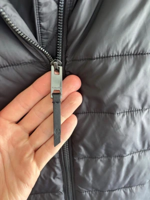 Svart cardigan från Massimo dutti - Snygg svart pufferjacka med quiltad framsida och släta ärmar. Jackan har en robust dragkedja med läderdetalj och ribbade muddar vid ärmslut och nederkant. Perfekt för kalla höst och vinterdadar och har en modern, stilren look. Storlek m men passar S