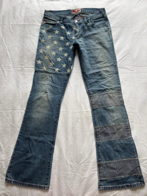 Miss sixty lågmidjade jeans  - Låga bootcut jeans storlek w29 passar en liten M  från miss sixty. Cool design med mycket detaljer. Eftersom höger ben har sömmar är dem väldigt tajta där om man har tjocka vader! Ingen stretch där. Ok skick men legat på vind i många år så luktar mycket gammalt!! Midjemått: 38cm gren: 18cm innerbenslängd: 80cm ytterben: 105cm bredd nertill på höger ben (smalare) 23cm 