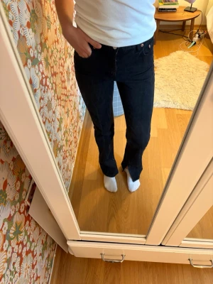 Svarta raka jeans med hög midja Zara  - Snygga svarta jeans med rak passform och hög midja. Jeansen har klassiska fem fickor och stängs med knapp och dragkedja. Passar perfekt till en enkel topp eller hoodie för en clean look.