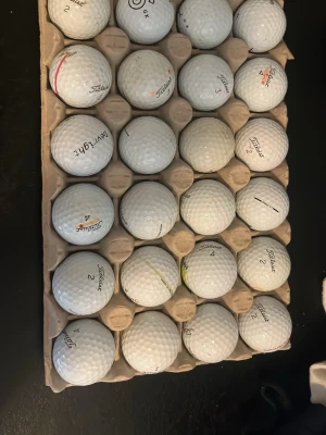 Golfbollar Titleist Pro V1, 24-pack - Säljer ett 24-pack golfbollar i A/B klassen av modellen Titleist Pro V1. Bollarna har klassisk dimple-yta och levereras i en kartongbricka. Perfekt för dig som vill fylla på golfväskan med kvalitetsbollar.