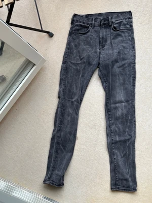 Grå skinny jeans från &Denim - Säljer ett par grå skinny jeans från &Denim i storlek 31. Jeansen har en tvättad look, klassisk femficksmodell och smal passform. Perfekta för dig som gillar en tajtare stil och vill ha ett par bekväma jeans i stretchigt material.